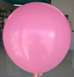 a person holding a large pink balloon in their hand