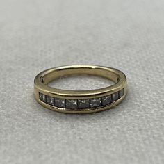 a gold ring with two rows of diamonds on the inside and outside, sitting on a white surface