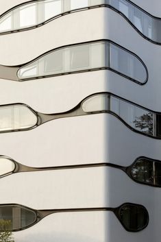 a tall white building with curved windows on the side