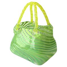 a green and yellow handbag with handles on it's sides, in front of a white background