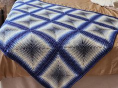 a blue and white blanket on top of a bed