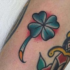 a close up of a person's leg with a tattoo on it and a clover