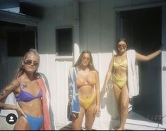 three beautiful women in bikinis standing next to each other