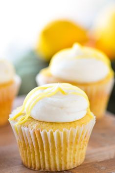 three cupcakes with white frosting and lemon slices