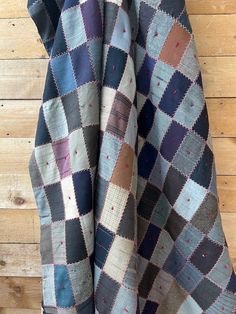 a blue and brown checkered blanket hanging on a wooden wall