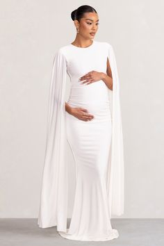 Sculpt your silhouette in our latest maternity design. Divine Timing. Arriving in a crisp white shade. this maxi dress has everything you need to stand out from the crowd at your next black tie event. What defines this opulent piece is its long cape sleeves and floor-sweeping length. For the perfect dinner party ensemble. try styling Divine Timing with a sleek bun and some statement earrings. Features - Premium stretch jersey- Button-closed crew neckline- Keyhole cut-out- Long cape sleeves- Invi White Maternity Maxi Dress, Dress With Cape Sleeves, Perfect Dinner Party, Dress With Cape, Long Cape, Gorgeous Maxi Dresses, Sleek Bun, Maternity Maxi Dress, Perfect Dinner