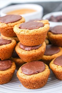 chocolate frosted cupcakes stacked on top of each other with dipping sauce in the background