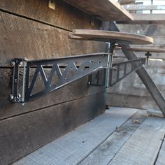 an ironing board mounted to the side of a wooden wall next to a bench