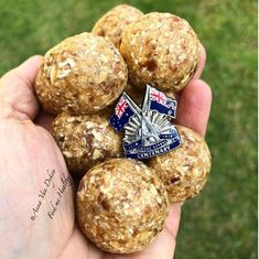 a person holding some food in their hand with an australian flag pin on the top