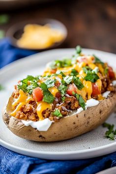 a loaded baked potato on a plate with cheese and cilantro garnish