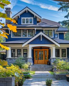 a blue and white house with lots of windows on the front door, steps leading up to