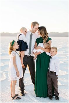 a family poses for a photo in the snow with their two children and one adult