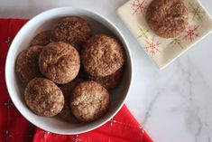 a white bowl filled with cookies next to a red and white napkin on top of a table