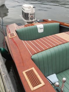 a small boat with two seats in the water next to another boat on the dock