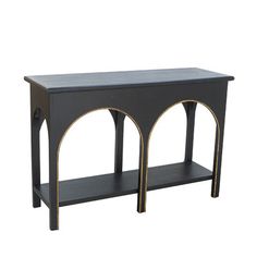 a black and gold console table with two arches on the top, against a white background