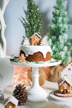 there is a cake on the table with gingerbreads and trees in the background