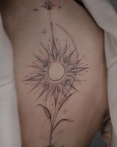 a woman's back with a sunflower tattoo on it