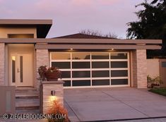 a house with a large garage and steps leading up to the front door at dusk