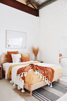 a bedroom with a bed, mirror and rugs on the floor in front of it