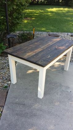 a wooden table sitting on top of a cement ground