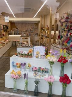 a flower shop filled with lots of flowers and vases full of different types of flowers