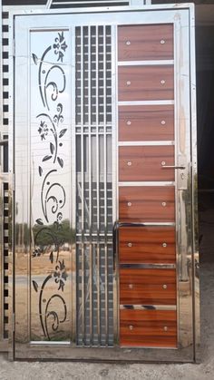 an open metal door with wooden panels and designs