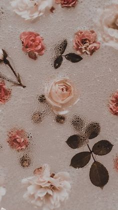 pink and white flowers are floating in water on a tablecloth with black dots around them