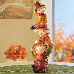 three ceramic figurines are stacked on top of each other in the shape of scarecrows