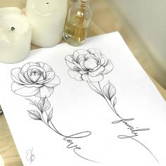 two roses are drawn on a piece of paper next to some candles and an ink pen