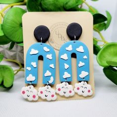 a pair of blue and white earrings with clouds