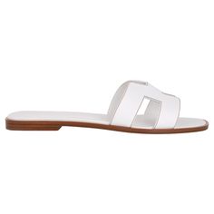 Mightychic offers a pair of Hermes Oran White leather sandals. The iconic top stitched H cutout over the top of the foot. This Hermes Oran slide shoe is accentuated with Havane topstitch. Natural wood heel with leather sole. Comes with sleepers and and signature Hermes box. NEW or NEVER WORN final sale SIZE 40 USA SIZE 10 SHOE MEASURES: HEEL .5" UPPER SOLE 10" CONDITION: NEW or NEVER WORN Hermes Oran White, Hermes Slides, Hermes Oran Sandals, White Leather Sandals, Modernist Jewelry, Hermes Shoes, Hermes Oran, Hermes Box, Kelly Bag