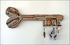 a key holder made out of driftwood is hanging on the wall next to keys