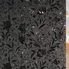 an intricately designed wallpaper with flowers and leaves on it's black background