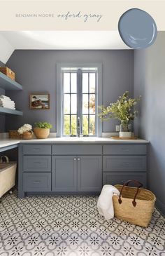 a kitchen with gray cabinets and white counter tops, an open window above the sink