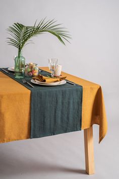 a table topped with plates and glasses next to a potted plant