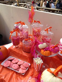 a table topped with lots of candy and candies on top of an orange cloth