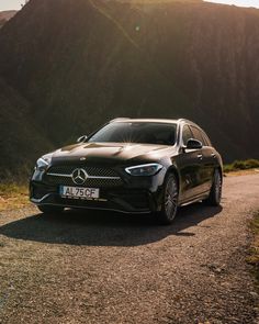 a black car parked on the side of a mountain road