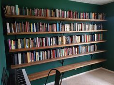 the bookshelves are filled with many different types of books and there is a piano in front of them