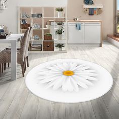 a large white flower sitting on top of a wooden floor next to a dining room table