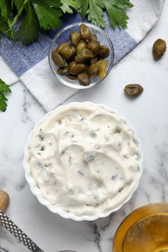 an image of a bowl of dip with olives and parsley on the side