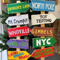 a christmas tree decorated with wooden signs that read, grinch's lake, north pole, mr crumpt, toy testing, whiffle gimbles, and new york