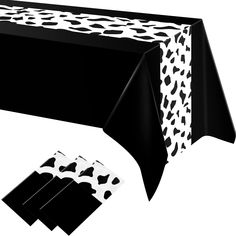 a black table cloth with white spots on it and four napkins under the table