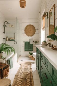 a bathroom with green cabinets and white walls