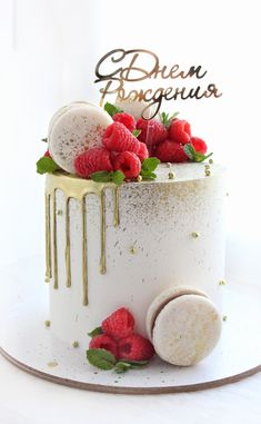 a white cake with raspberries on top and gold lettering that reads bohemian bougnerus