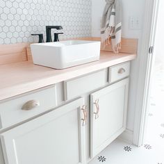 a bathroom with white cabinets and a sink