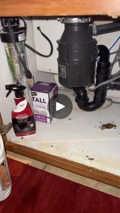 a bathroom under the sink with toilet paper and cleaning products on it's floor