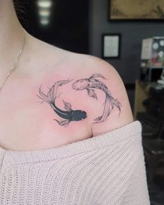 a woman with a tattoo on her shoulder has a fish in it's stomach