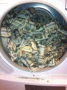 a pile of money sitting inside of a dryer in front of a sign that says mentras