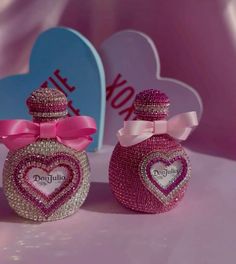 two pink perfume bottles with hearts on them