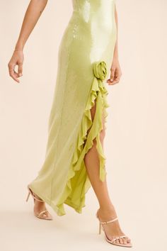 a woman in a lime green dress with ruffles on the skirt and heels